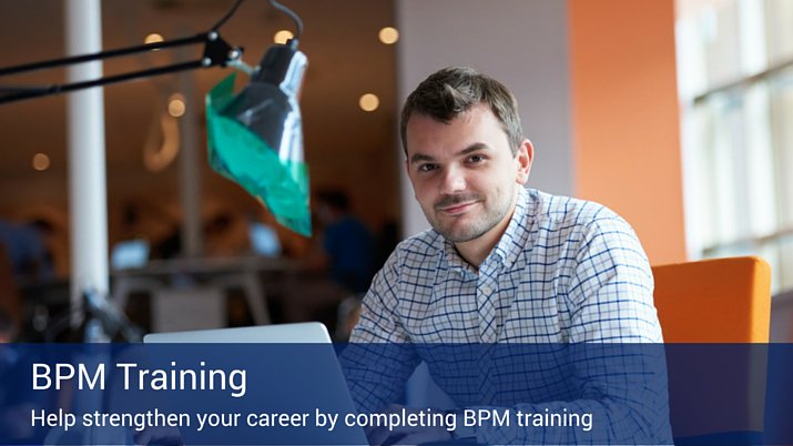 A man working at his desk on a computer next to a large desk lamp. There is a banner that reads "BPM Training" across the bottom of the image.