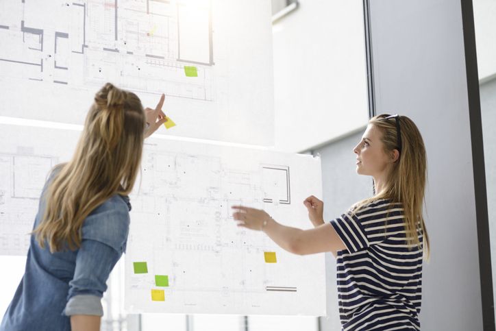 Two businesswomen plan out a project.