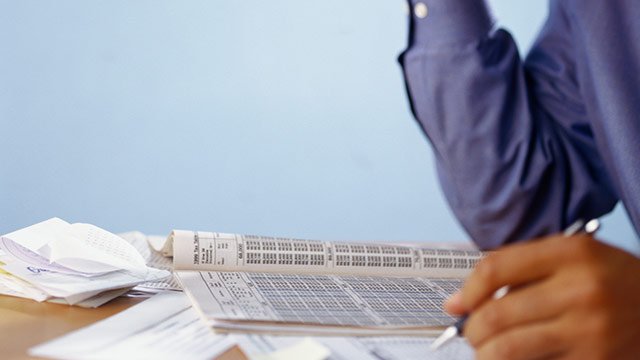 A man reading a book filled with numbers.