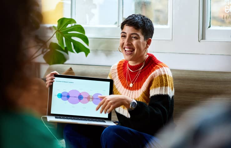 Hispanic woman sharing computer graphics with creative team, innovation, future, teamwork
